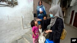 A health worker administers a polio vaccine to a child in Karachi, Pakistan, Nov. 27, 2023.