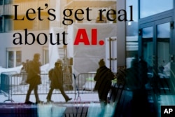 People reflected in a window of a hotel at the Davos Promenade with a slogan about AI, a theme of the World Economic Forum in Davos, Switzerland, Jan. 15, 2024.