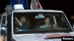 A Red Cross vehicle, as part of a convoy carrying hostages abducted by Hamas militants during the October 7 attack on Israel, arrives at the Rafah border, in the southern Gaza Strip, Nov. 26, 2023. 