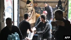Volunteers unload water, food and other goods donated for residents of flooded area in Kherson on June 11, 2023, following damages sustained at Kakhovka hydroelectric power plant dam.