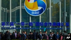 FILE - Volunteers lead as attendees arrive at the China National Convention Center after the opening ceremony of the third Belt and Road Forum in Beijing, Oct. 18, 2023.