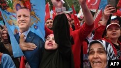 Supporters of Turkish President wave a flag depicting Recep Tayyip Erdogan in front of AK Party's headquarter in Istanbul on the day of the Presidential runoff vote in Istanbul, on May 28, 2023.