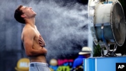 Poland's Jerry Janowicz is sprayed with cool water at the Australian Open tennis championship in Melbourne, Australia, Thursday, Jan. 16, 2014.