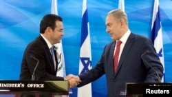 FILE - Guatemalan President Jimmy Morales and Israeli Prime Minister Benjamin Netanyahu shake hands as they deliver statements to the media during their meeting in Jerusalem, Nov. 29, 2016. 