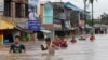 Warga mengarungi banjir yang dibawa hujan monsoon dan diperburuk oleh badai tropis Trami, di Cavite, bagian selatan Manila (19/8). (Reuters/Romeo Ranoco)