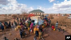 FILE - Water is distributed at a camp for displaced people on the outskirts of Dollow, Somalia, Sept. 20, 2022. 