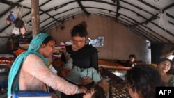 A health worker administers polio vaccine drops to a child during a vaccination campaign in Lahore, Pakistan, Oct. 24, 2022. 