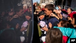 Locals receive food and everyday necessities given by Ukrainian volunteers in Izium, Ukraine, Oct. 12, 2022. Residents in Izium have been living with no gas, electricity or running water supply since beginning of September.