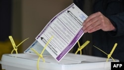 A voter casts his ballot at a polling station in Sarajevo on Oct. 2, 2022.