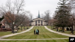 FILE - In this Dec. 9, 2014 file photo students walk on the mall at Adrian College in Adrian, Michigan. (AP Photo/Carlos Osorio/File photo)