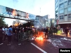 Demonstran menyalakan api selama protes atas kematian Mahsa Amini saat berada dalam tahanan "polisi moral" Iran di Teheran, 21 September 2022. (WANA via Reuters)