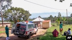 FILE - A medical officer from the Uganda Red Cross Society instructs people with suspected Ebola symptoms to enter an ambulance, near Mubende, in Uganda, Sept. 29, 2022.
