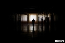 A maternity hospital employee brings meals provided by the NGO World Central Kitchen, to patients during an electricity power cut due to a Russian missile attack, in Mykolaiv, Ukraine, Oct. 22, 2022.