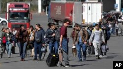 A group of Russians walk after crossing the border at Verkhny Lars between Georgia and Russia, in Georgia, Sept. 27, 2022. After President Vladimir Putin ordered a mobilization to bolster his troops in Ukraine, many Russians are leaving their homes.
