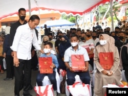 Indonesian President Joko Widodo meets with relatives of the victims of a riot and stampede following a soccer match between Arema vs Persebaya Surabaya in Malang, East Java province, Indonesia, Oct. 5, 2022. (Indonesia Presidential Palace/Handout via Reuters)