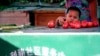 FILE - A Uyghur child plays with tomato at a street vender in Urumqi, western China's Xinjiang province, July 11, 2009. 