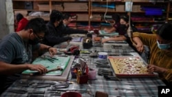 Artisans make "papel picado", the traditional manufacture of tissue paper cut-out decorations long used in altars for the Day of the Dead, in a workshop in Xochimilco, a borough of Mexico City, Oct. 27, 2022.