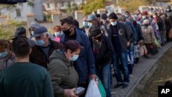 People queue up to wait a ration food from World Central Kitchen organisation in the center of Mykolaiv, Oct. 24, 2022. 