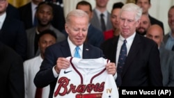 Atlanta Braves CEO Terry McGuirk watches as President Joe Biden regards the gift of a Braves jersey, Monday, Sept. 26, 2022, in Washington. 