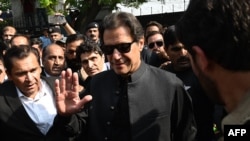 Mantan Perdana Menteri Pakistan Imran Khan (tengah) memberi isyarat saat dia pergi setelah muncul di hadapan Pengadilan Tinggi di Islamabad pada 22 September 2022. (Foto: AFP)