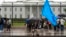 FILE - A member of the District of Columbia's Uyghur community sits in the rain as the East Turkistan Awakening Movement rallies outside the White House against the Chinese Communist Party, in Washington, Oct. 1, 2022. 