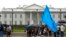 A member of the District of Columbia's Uyghur community sits in the rain as the East Turkistan Awakening Movement holds a rally outside the White House against the Chinese Communist Party (CCP) to coincide with the 73rd National Day of the People's Republ