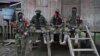 ARCHIVO - Rebeldes del Ejército de Liberación Nacional colombiano descansan afuera de una casa cerca del río San Juan, Colombia, en agosto de 2017.