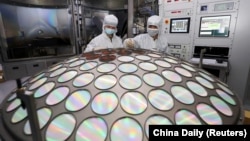 Работници работат на производство на полуспроводнички чипови во провинцијата Џиангсу, Кина, 25 март 2022 година