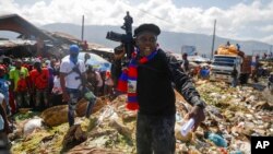 FILE - Barbecue, the leader of the G9 and Family gang, stands next to garbage to call attention to the conditions people live in as he leads a march against kidnapping through La Saline neighborhood in Port-au-Prince, Haiti, Oct. 22, 2021.
