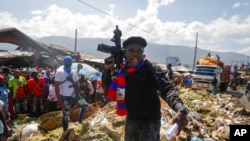 FILE - Barbecue, the leader of the G9 and Family gang, stands next to garbage to call attention to the conditions people live in as he leads a march against kidnapping through La Saline neighborhood in Port-au-Prince, Haiti, Oct. 22, 2021.