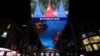 FILE - A giant screen shows news footage of Chinese national and European Union flags during an EU-China virtual summit, in Beijing, China, April 1, 2022.