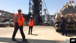 Workers stand at the Khurais oil field in Khurais, Saudi Arabia, Sept. 20, 2019. The OPEC+ coalition on Oct. 5, 2022, slashed production by 2 million barrels a day.