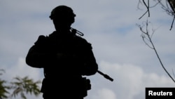 FILE - A soldier from the Australian Army's 3rd Brigade guards Langham Beach during joint military exercises between Australia and the United States in northeast Australia, July 13, 2017. This week, Australia said it will deploy troops to Britain to train Ukrainian forces. 