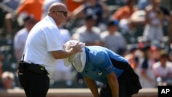 Baltimore Orioles head trainer Brian Ebel, left, helps home plate umpire Scott Barry get relief with a wet towel around his head after the sixth inning of a baseball game between the Orioles and the New York Yankees, July 24, 2022, in Baltimore. The Yankees won 5-0.