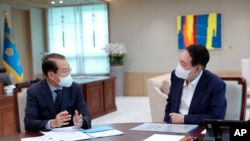 In this photo provided by South Korea Presidential Office, South Korean President Yoon Suk Yeol, right, listens to Unification Ministry's policy briefing by Unification Minister Kwon Youngse at the presidential office in Seoul, South Korea, July 22, 2022.