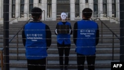 FILE - Activists set up a mock Uyghur forced labor camp during a protest in Washington, D.C., March 4, 2022.