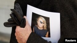 Un hombre sostiene un cartel que honra a la periodista del Sunday Times, Marie Colvin, después de un servicio memorial, en Londres, el 16 de mayo de 2012.