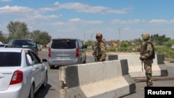 Uzbek service members guard a road in Nukus, capital of the northwestern Karakalpakstan region, Uzbekistan, July 6, 2022. 
