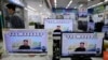 FILE: A man walks past TV monitors displaying a news program at an electronic shop in Seoul, South Korea, on Oct. 14, 2014, showing a North Korean newspaper with a photo of North Korean leader Kim Jong Un smiling.
