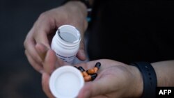 FILE - Kyle Planck, who has recovered from monkeypox, shows Tecovirimat capsules, which is used for monkeypox treatment, during an interview in New York, July 19, 2022. 