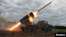 Ukrainian servicemen fire with a BM21 Grad multiple launch rocket system in a frontline in Kharkiv region, as Russia's attack on Ukraine continues, Aug. 2, 2022. 
