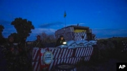 Ukrainian servicemen stand guard at a checkpoint, during nighttime curfew, in Donetsk region, eastern Ukraine, July 22, 2022.