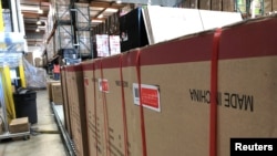 FILE - Boxes marked "Made in China" are lined up in a warehouse in Cypress, California, May 24, 2019. 