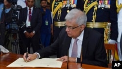 IFILE - n this photo provided by Sri Lankan President's Office, Sri Lanka's newly elected president Ranil Wickremesinghe, signs after taking oath during his swearing-in ceremony in Colombo, July 21, 2022.