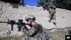 US Army soldiers from Charlie company 4th platoon,1st brigade 3-21 infantry, jump over a wall during a patrol in the village of Chariagen in the Panjwai district of Kandahar province southern Afghanistan . President Barack Obama unveiled his plan to start