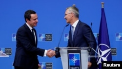 NATO Secretary-General Jens Stoltenberg shakes with Kosovo's Prime Minister Albin Kurti in Brussels, Aug. 17, 2022.