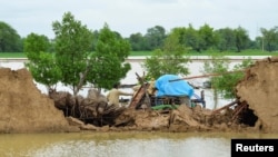 A flood victim retrieves usable items from his damaged house following rains and floods during the monsoon season in Jafarabad, Pakistan, Aug. 26, 2022. 