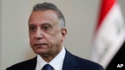 FILE - Iraqi caretaker Prime Minister Mustafa al-Kadhimi poses in his office during an interview, in Baghdad, Iraq, July 23, 2021.
