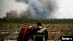 Firefighters react as they work to contain a fire in Saint-Magne, as wildfires continue to spread in the Gironde region of southwestern France, Aug. 11, 2022. 