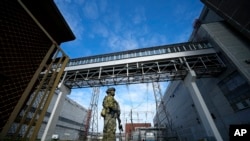 FILE - A Russian serviceman guards an area of the Zaporizhzhia Nuclear Power Plant in territory under Russian military control, southeastern Ukraine, May 1, 2022. Russia and Ukraine have traded blame over shelling of areas near the plant.